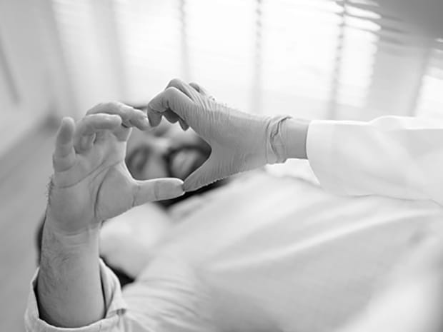 Transplant patient putting hands into shape of heart 