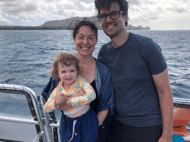 Diana Smith pictured holding toddler while on a boat in the ocean with partner