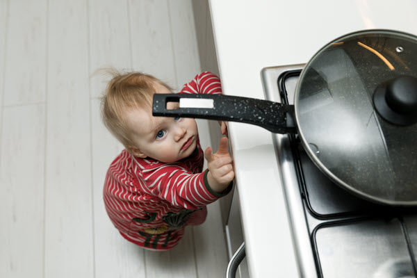 baby reaching for pan on stove